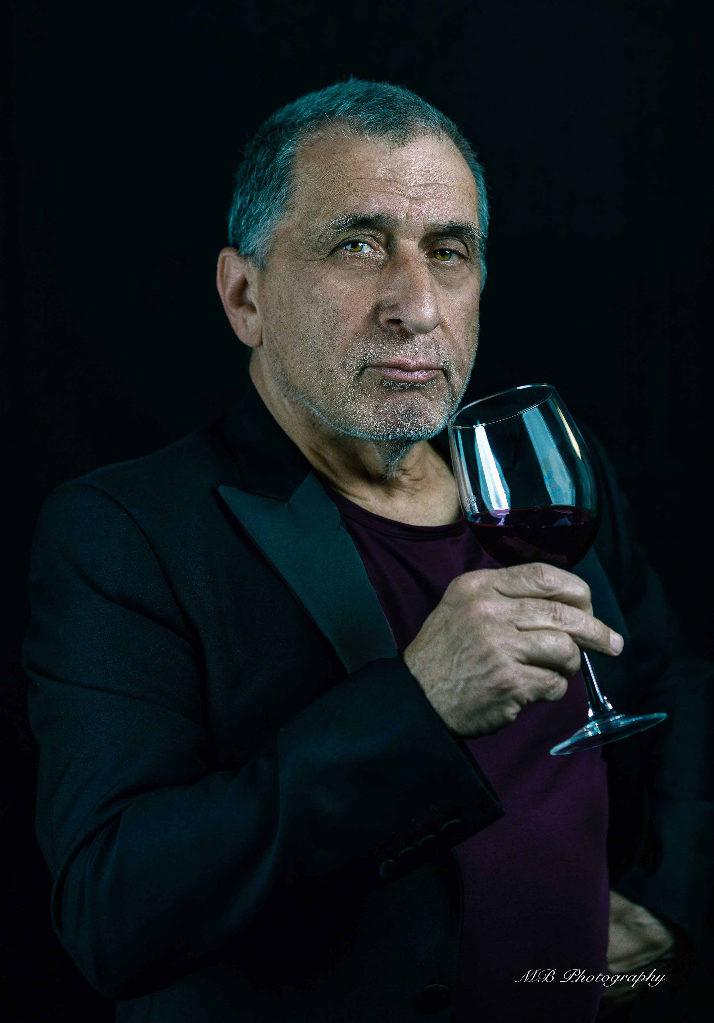 man drinking a glass of red wine