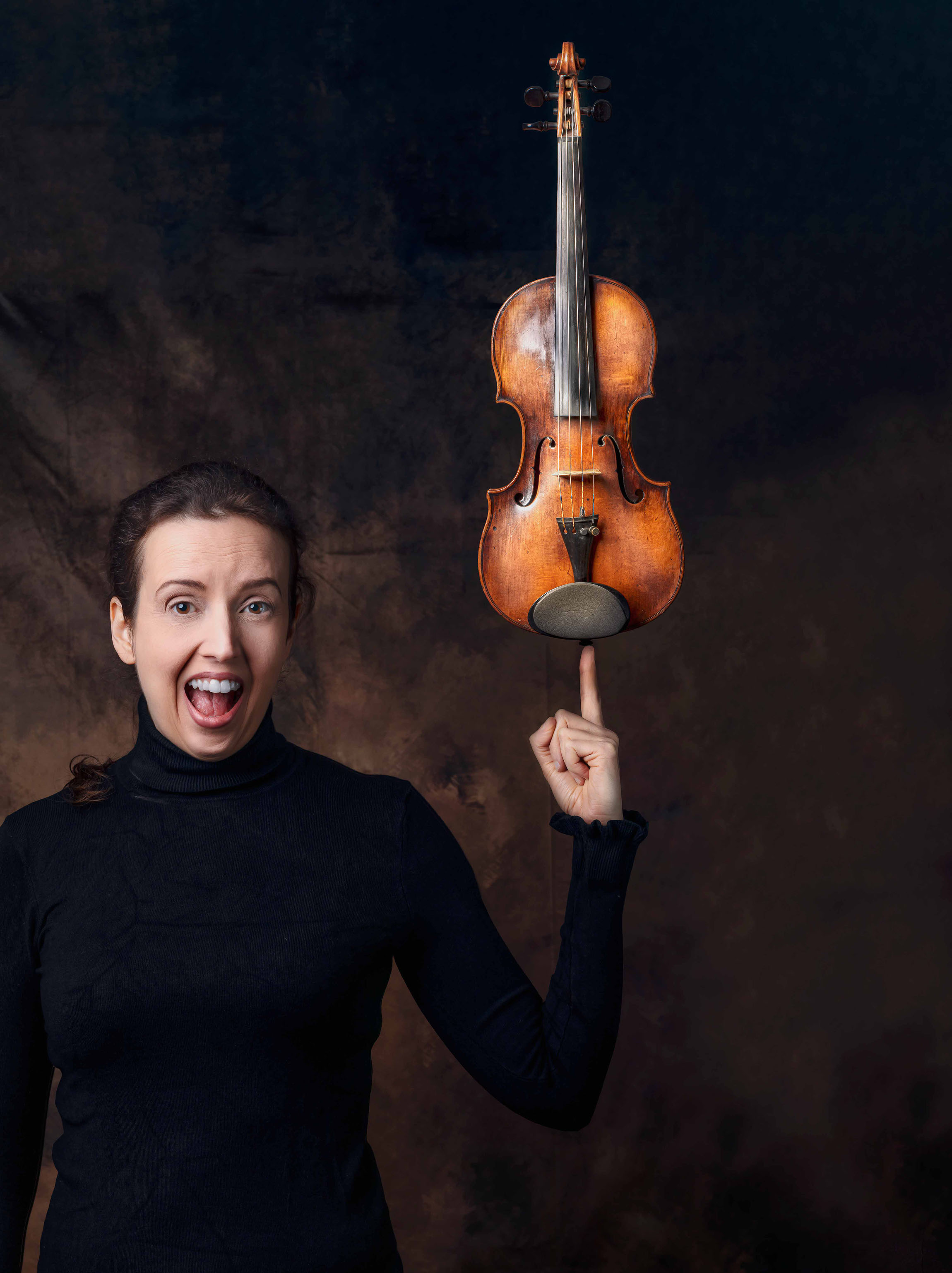 violinist holding her violin with one finger