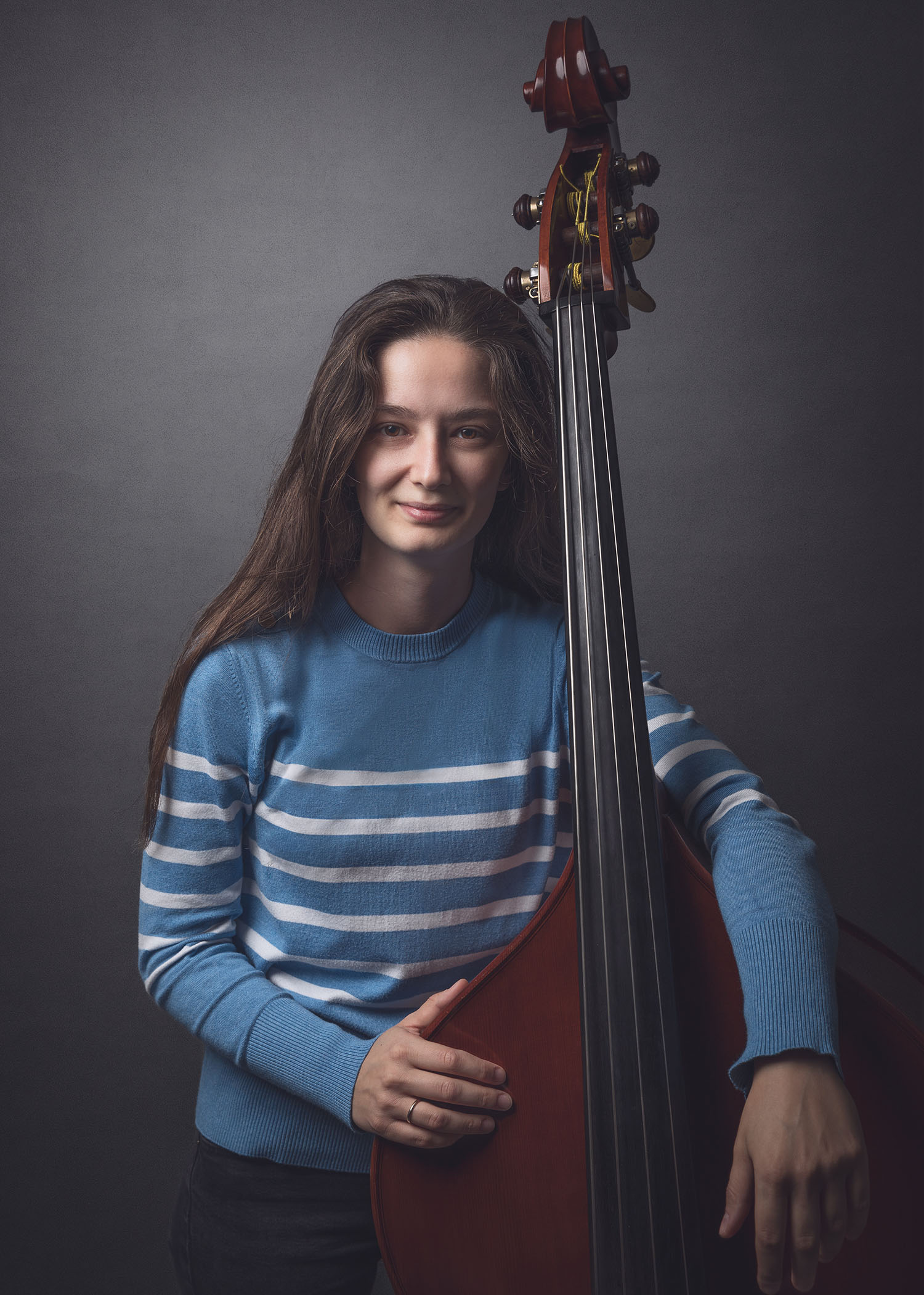 Kontrabassitin im blaue Pullover mit ihrem Instrument