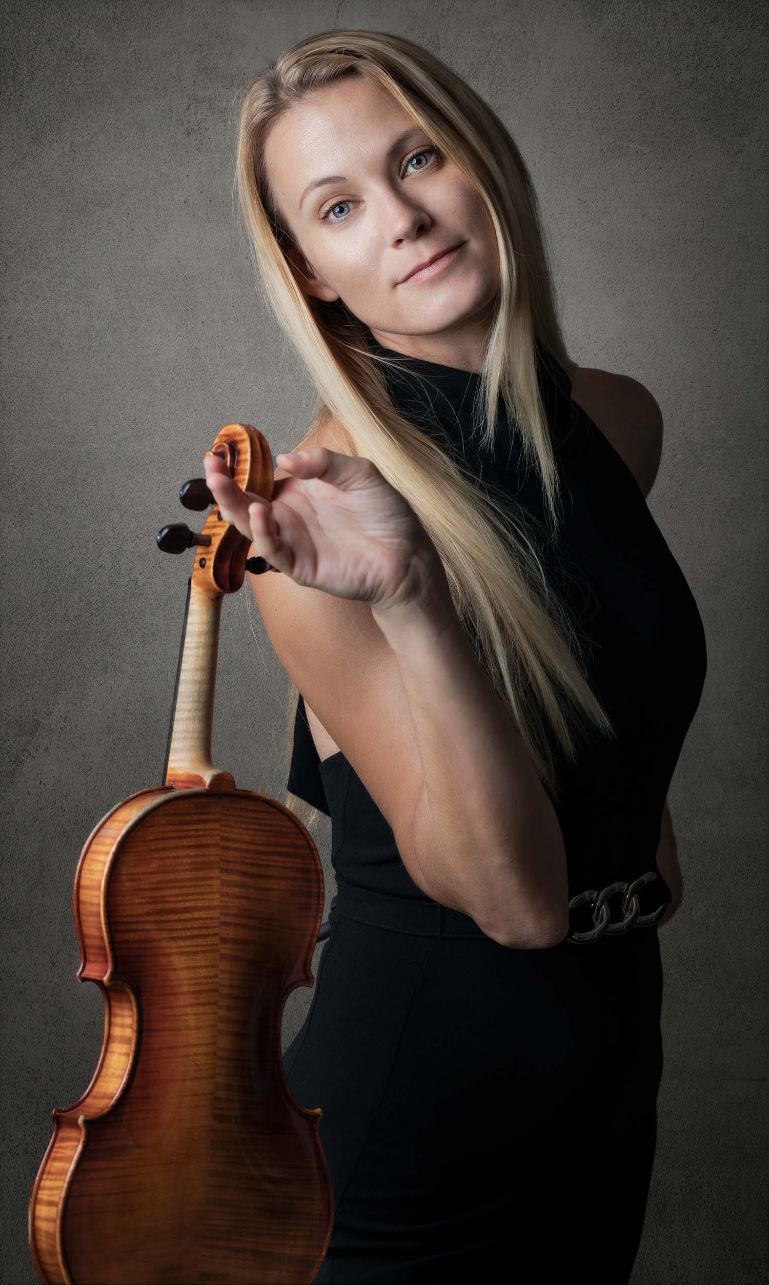 blond violinist with her violin in a black dress
